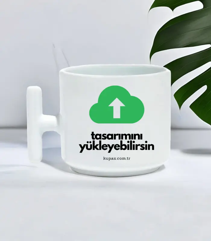 T Kulplu Kahve Fincanı | Kişiye Özel Kahve Fincanı, yeşil bir yükleme bulutu simgesi, Türkçe "tasarımını yükleyebilirsin" metni ve kupax.com.tr, beyaz bir arka plan üzerinde yeşil bir yaprağın yanında gösterilmiştir.