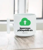Beyaz bir T Kulplu Kahve Fincanı | Kişiye Özel Kahve Fincanı, yeşil bir yükleme bulutu simgesi ve "tasarımını yükleyebilirsin" metni ile ahşap bir yüzeye oturur. Türkçe ibarenin altında kupax.com.tr web sitesi yazılıdır.
